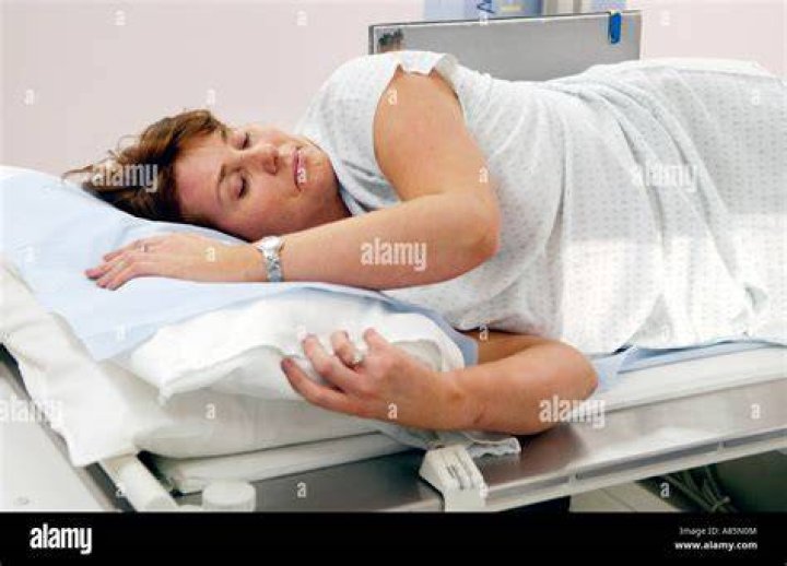 Woman having barium enema on table of Siemens Medical Solutions Axiom